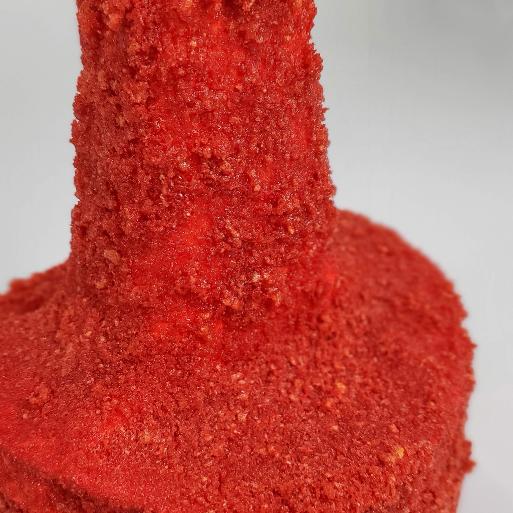 A abstract piston sculpture covered in hot Cheeto dust