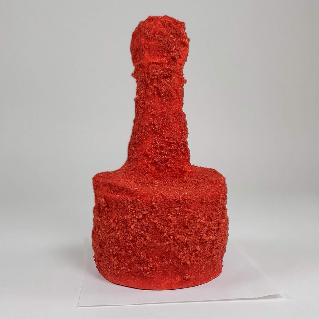 A abstract piston sculpture covered in hot Cheeto dust